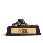 Dead Last fantasy football trophy: a bronze player lying face down under a football