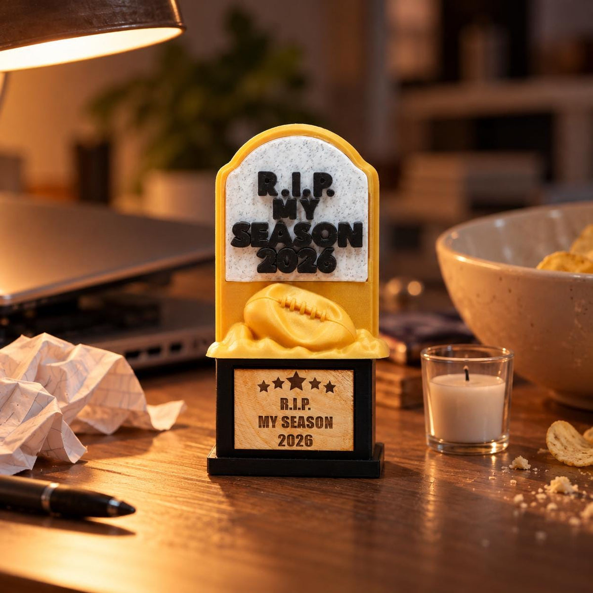 R.I.P. My Season trophy on a desk next to a candle