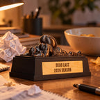 Dead Last trophy on a desk next to crumpled draft notes